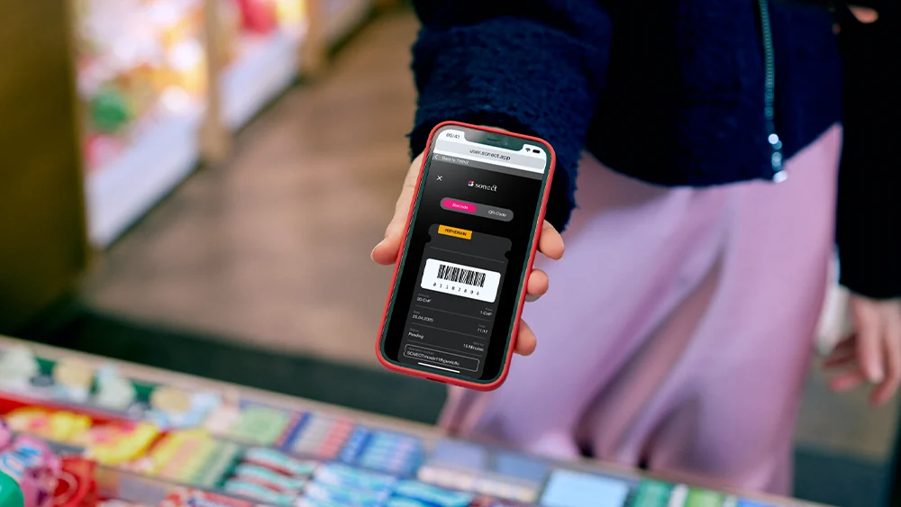 Handy mit Barcode für Geldbezug wird vorgezeigt