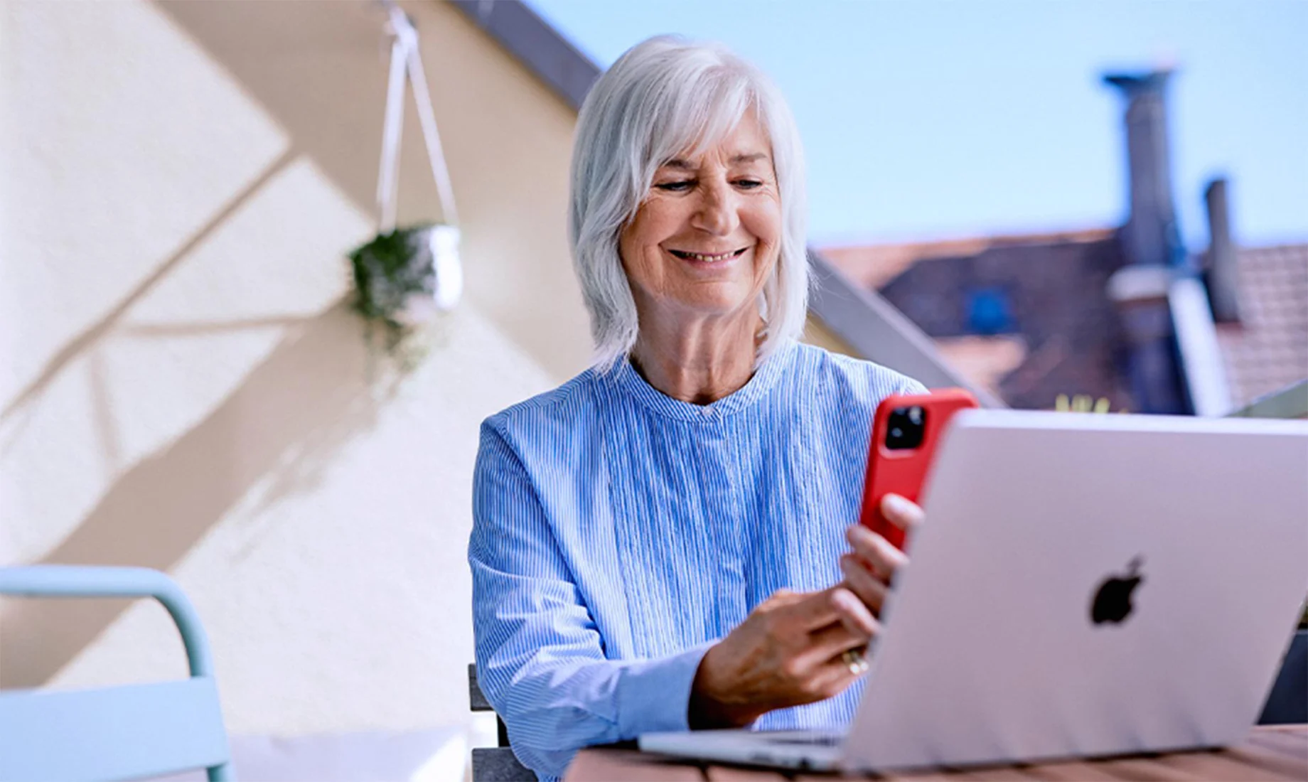 Glückliche Dame bezahlt mit Handy am Laptop